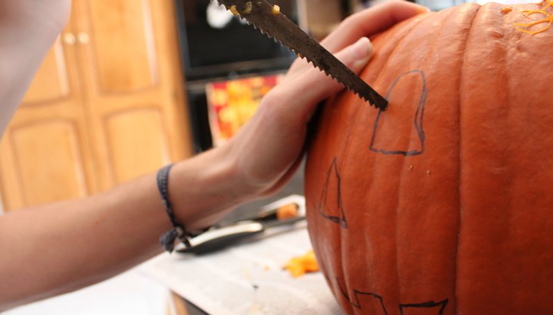 Kid carving pumpkin
