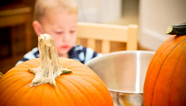 Kid carving pumpkin